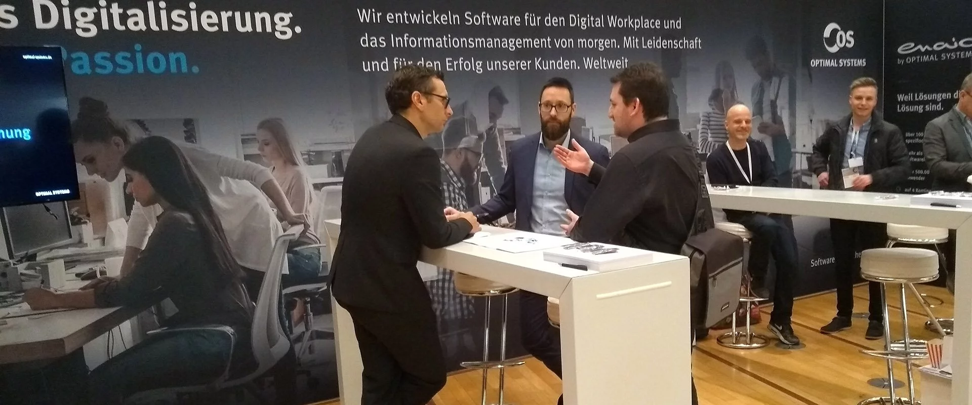 Eine Gruppe von Menschen diskutiert an einem Stand auf der Fachmesse DIGITAL FUTUREcongress über Fortschritte in der digitalen Technologie.