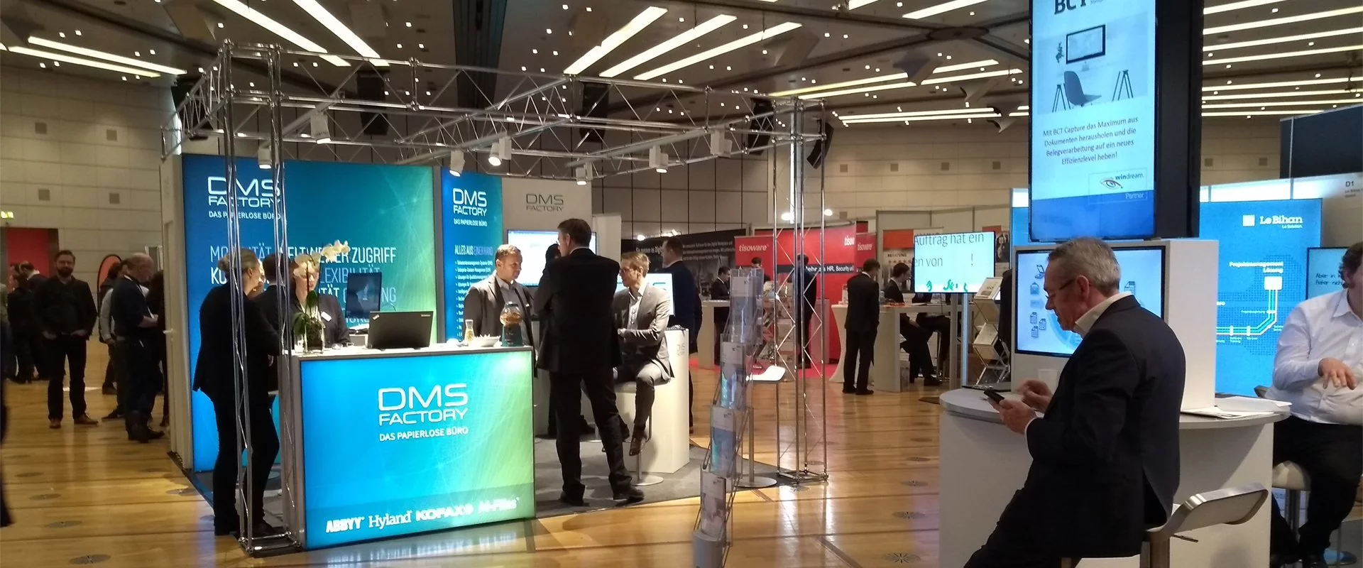 A group of people standing around a DIGITAL FUTUREcongress booth at a trade show.