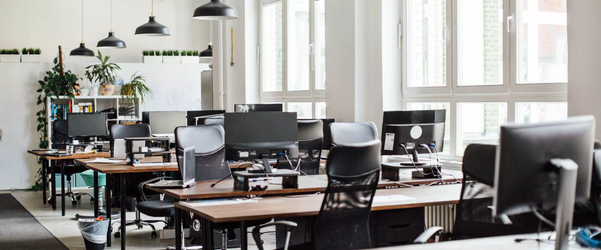 Ein leeres Büro mit vielen Schreibtischen und Monitoren
