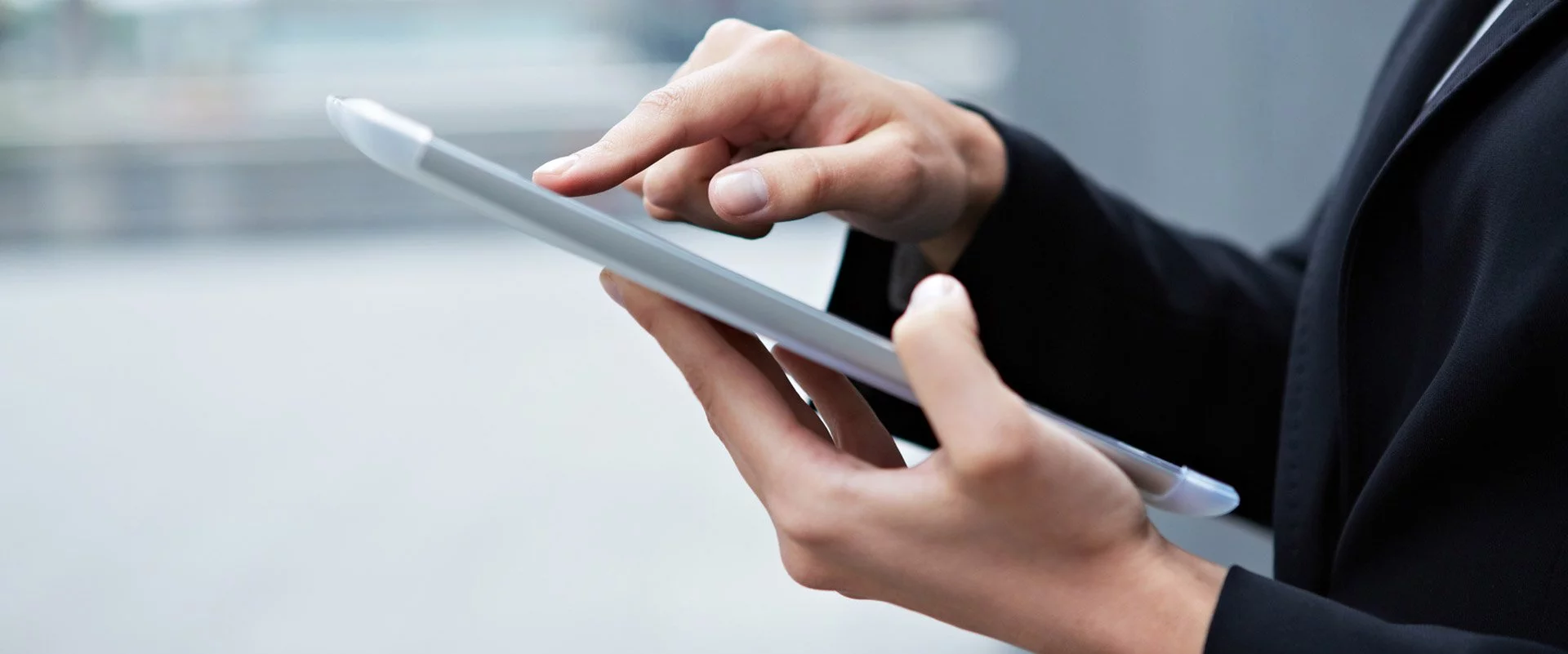 Frauenhände, die ein Tablet halten und darauf tippen