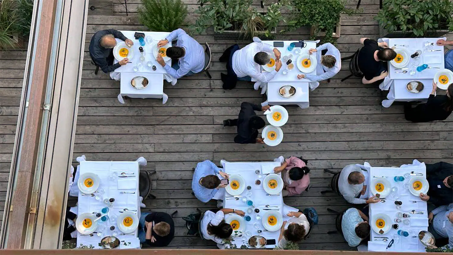 A group of people eating at tables on a rooftop.