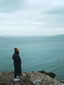 Eine Frau namens Tabea steht auf einer Klippe mit Blick auf den Ozean in Dublin.