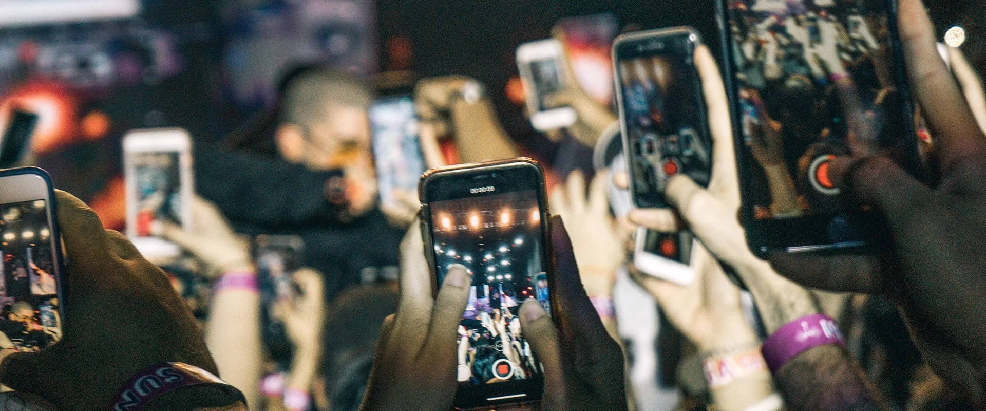 Eine Gruppe von Menschen nutzt mobile Lösungen, indem sie bei einem Konzert ihre Mobiltelefone hochhält.