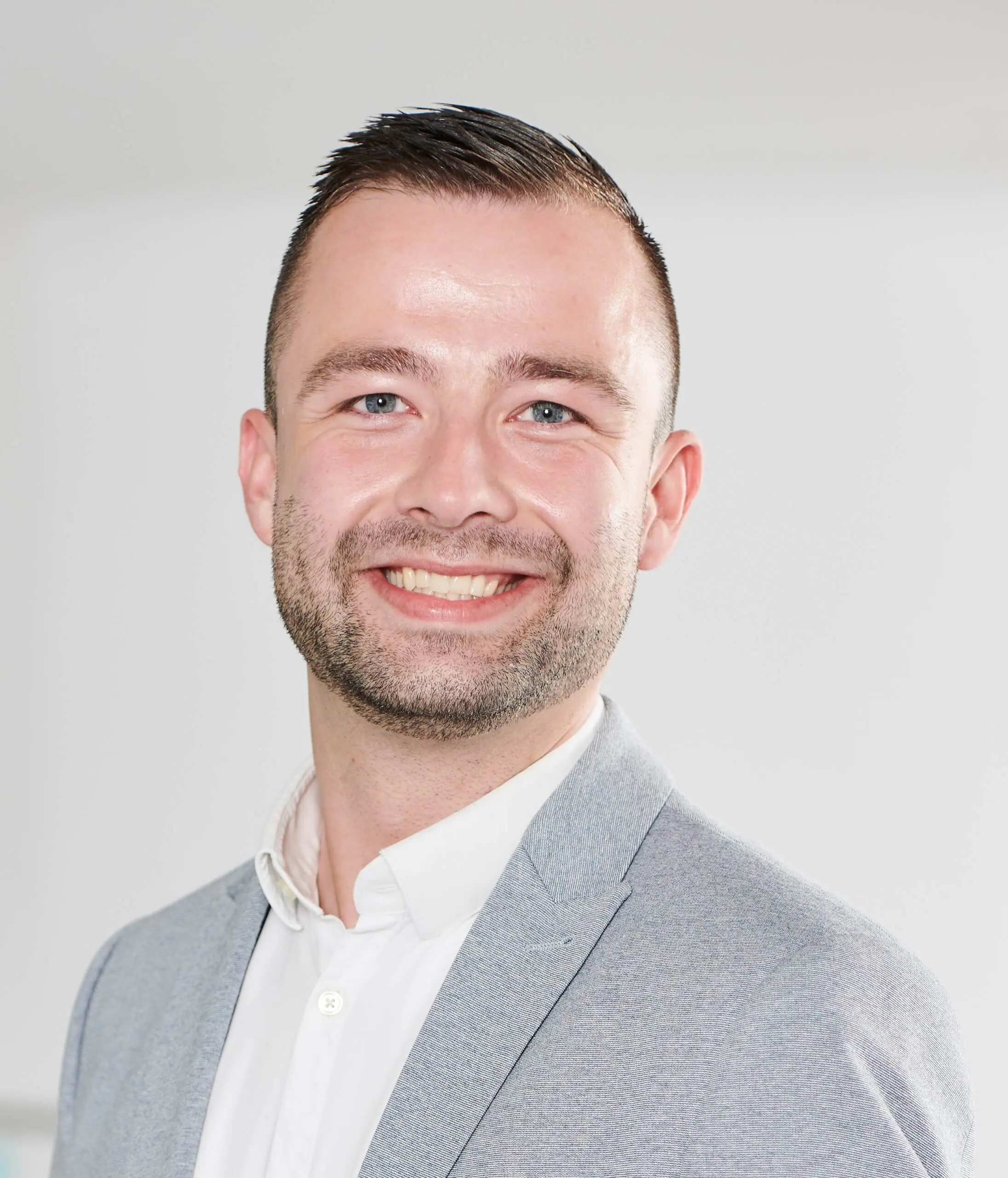 Ein zufriedener Mann im grauen Anzug, der die Vorteile der Client-Varianten enaio® genießt.