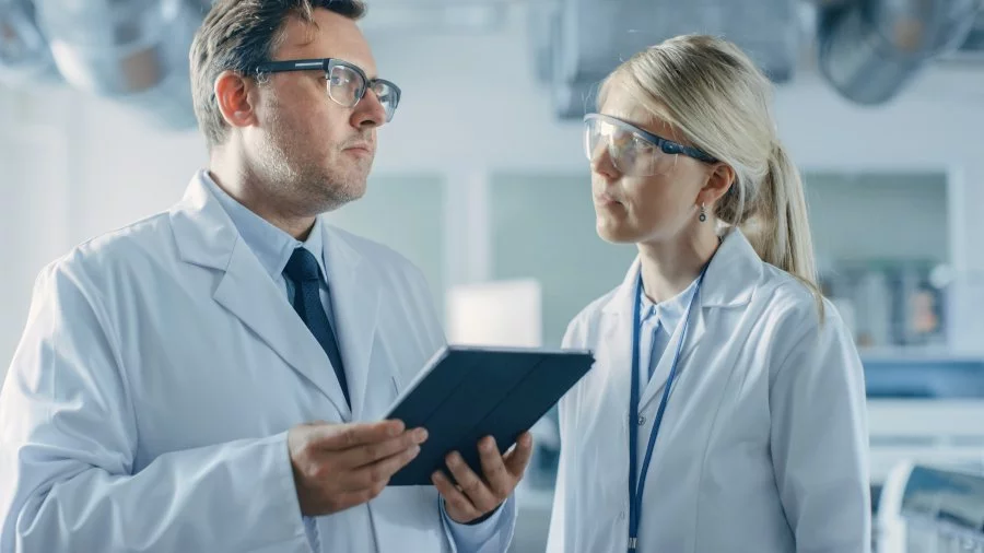 Zwei Personen in Laborkitteln nutzen ein Tablet für das Getemed-Beschwerdemanagement.