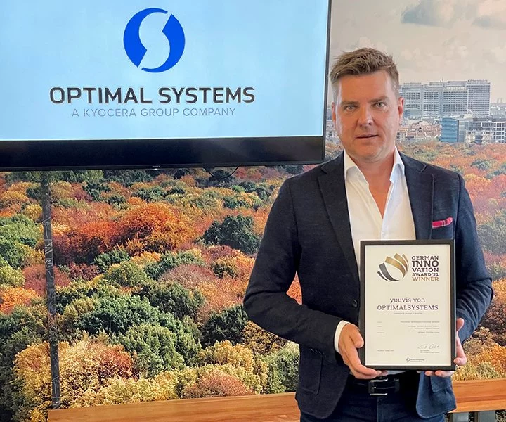 Ein Mann im Anzug hält den yuuvis German Innovation Award für optimale Systeme hoch.