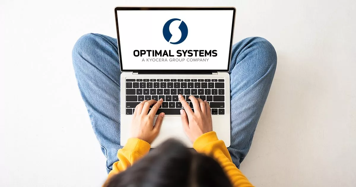 Frau nutz im Schneidersitz ein Laptop, auf dem das Logo von OPTIMAL SYSTEMS angezeigt wird