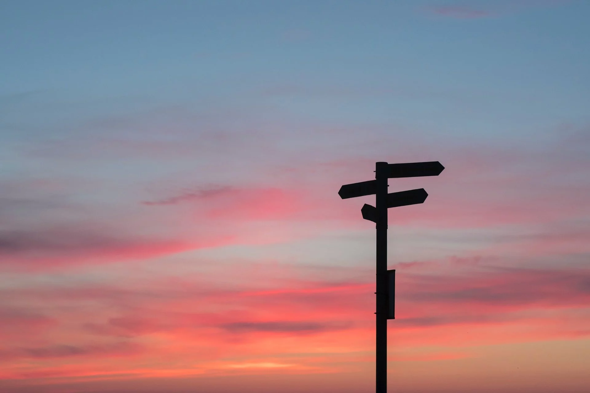 Wegweiser-Schild im Sonnenuntergang