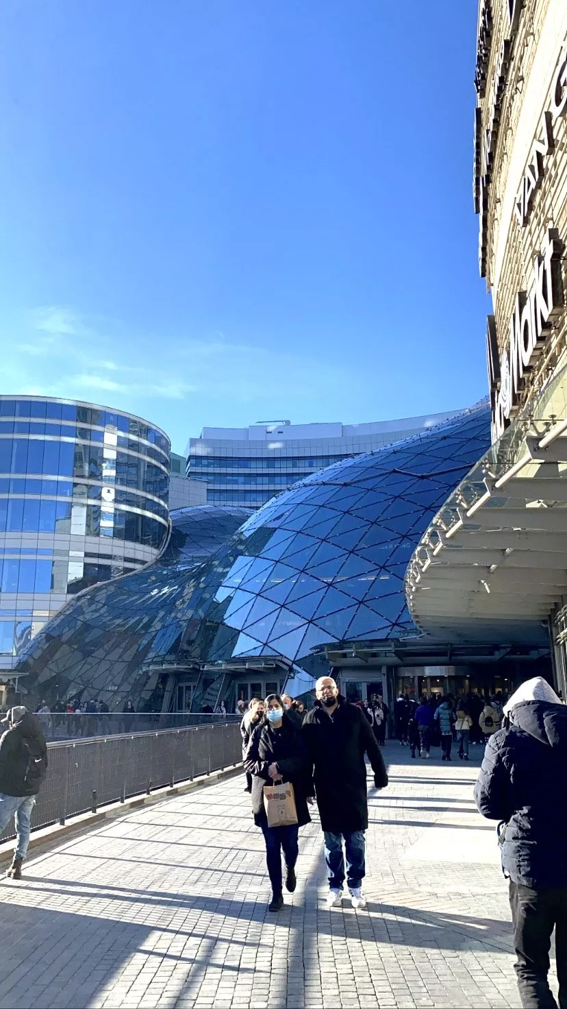 Eine Gruppe von Menschen geht vor einem Glasgebäude.