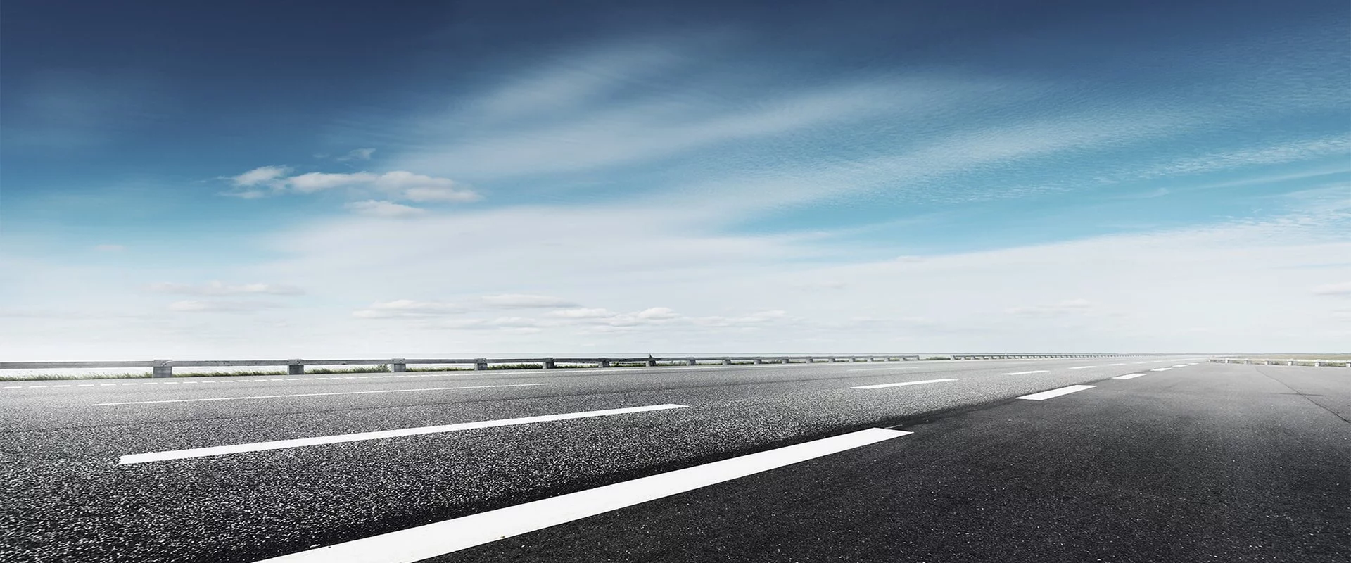 Eine leere Straße mit blauem Himmel, weißen Linien und Kontakt zu OPTIMAL SYSTEMS.