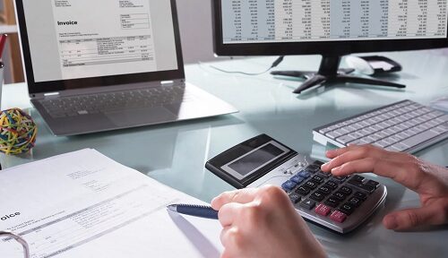 Eine Person benutzt einen Taschenrechner und einen Stift