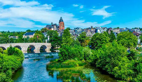 Eine malerische Aussicht auf Wetzlar mit einer alten Steinbrücke über einen Fluss.