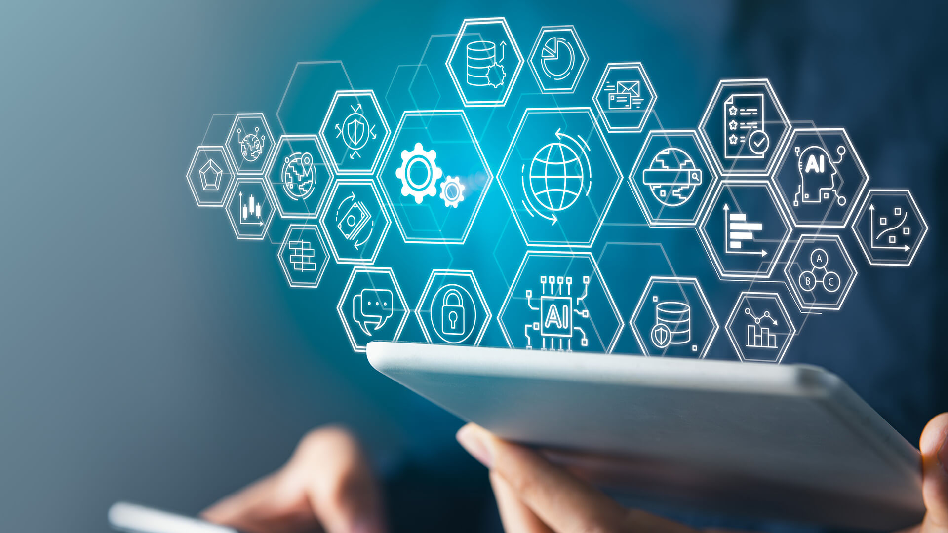 Hände halten ein Tablet, über dem digitale Symbole für Technologien wie Zahnräder, Cloud und Datenanalyse vor blauem Hintergrund schweben.