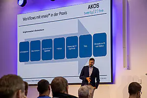 Ein Mann steht vor einem großen Bildschirm.