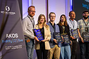 Sechs Personen mit Plaketten stehen neben einem "AKOS twenty | 2 | five"-Veranstaltungsbanner für September 2025 in Hannover.