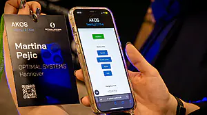 Eine Hand hält einen Ausweis für "Martina Pejic, OPTIMAL SYSTEMS, Hannover" und ein Telefon mit Feedback- und Quicklink-Optionen.