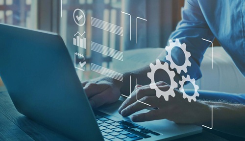 Person, die auf einem Laptop tippt, mit überlagerten digitalen Zahnrädern und Diagrammen, die Technologie und Automatisierung symbolisieren.