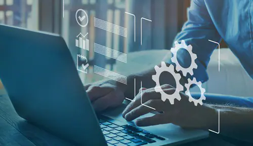 Person, die auf einem Laptop tippt, mit überlagerten digitalen Zahnrädern und Diagrammen, die Technologie und Automatisierung symbolisieren.