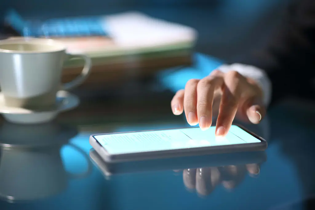 Eine Geschäftsfrau, die nachts auf ihrem Smartphone eine Online-Unterschrift leistet…